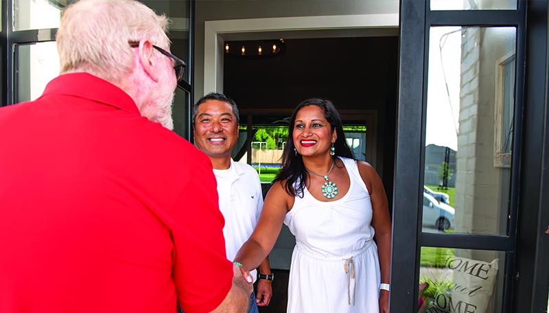 salesman greeting couple on porch