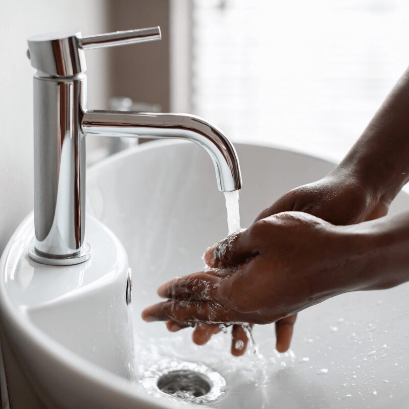 black man washing his hands at the sink